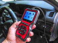 OBD2 scanner in hand, car diagnostic tool and code reader to che