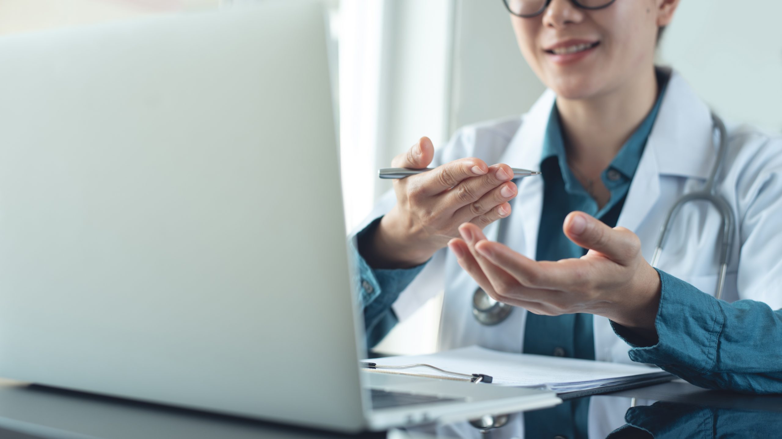Asian female doctor using laptop computer online video call, tel