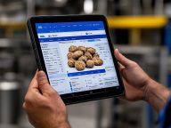 A person holds a tablet displaying an online interface with imag