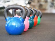 Colorful kettlebells in a row in a gym